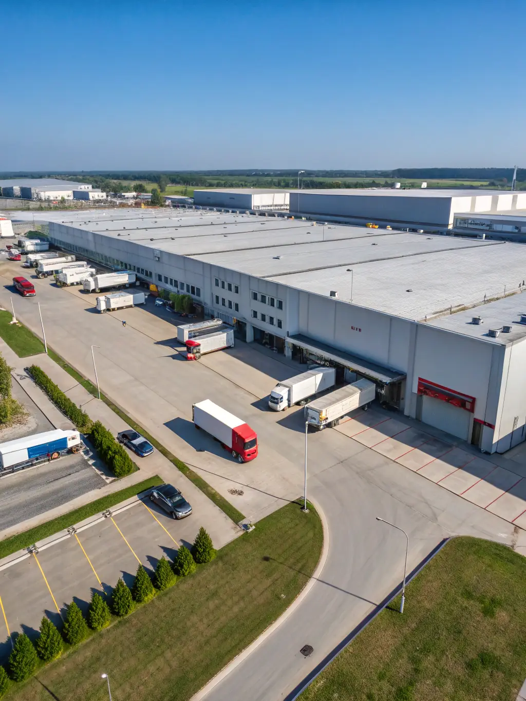 A wide-angle shot of Roadrunner Moving & Storage's Houston facility, highlighting its size and capacity, with trucks loading and unloading in a busy, efficient manner.